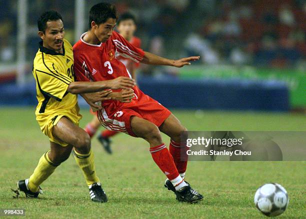 Hairuddin Omar of Malaysia challenges Nguyen Huy Hoang of Vietnam in a Group A Men's Under-23 Match between Malaysia and Vietnam held at the National...