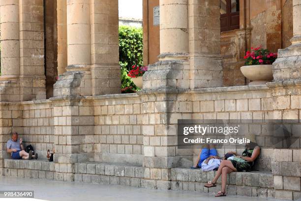 Tourists rest at Noto Town Hall on June 05, 2018 in Sicily, Italy. Noto is a city and comune in the Province of Syracuse, in 2002 Noto and its church...