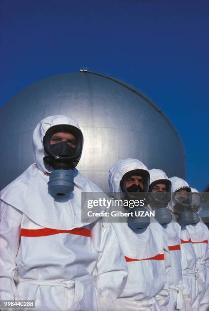 Techniciens équipés de combinaisons et de masques à gaz à la centrale nucléaire de Chinon en décembre 1976 en France.