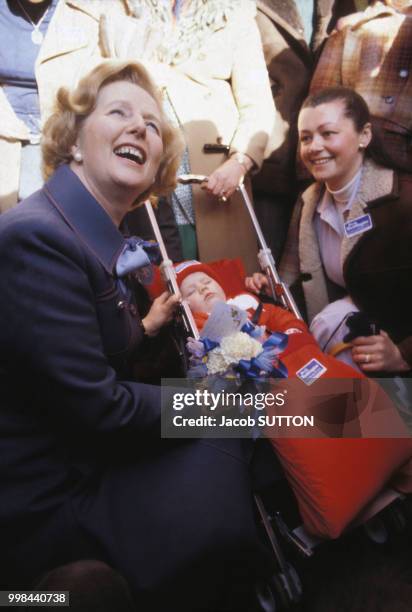 Margaret Thatcher au côté d'une mère et son bébé en 1979 à Harwood, Grande-Bretagne.