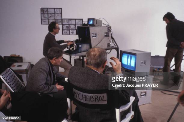 Claude Chabrol au côté du directeur de la photographie Henri Alekan sur le tournage d'un film publicitaire pour Dior le 4 février 1985 à Suresne,...