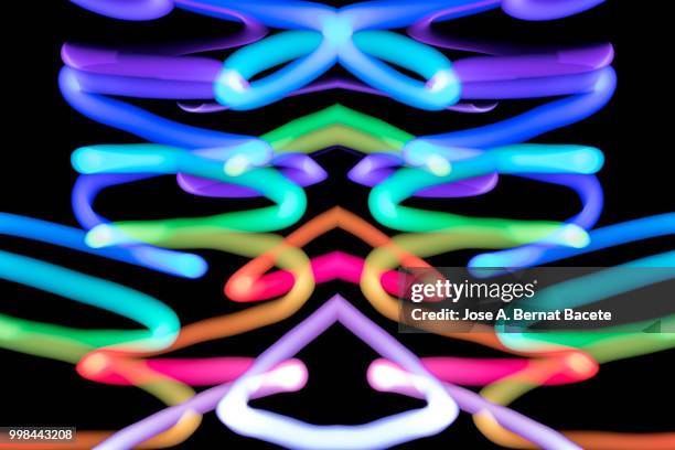 close-up abstract pattern of intertwined colorful light beams of color violet, green and red on a  black background. - bernat photos et images de collection