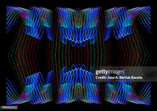 close-up abstract pattern of intertwined colorful light beams of color blue, green and pink on a  black background. - bernat photos et images de collection