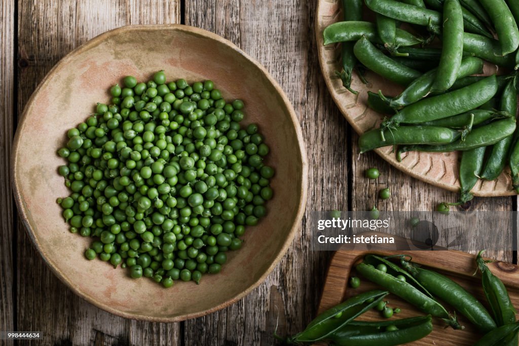 Young fresh green peas on wooden table