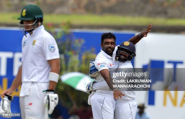 Sri Lanka's Dilruwan Perera celebrates with wicketkeeper Niroshan Dickwella after he dismissed South Africa's Hashim Amla during the third day of the...