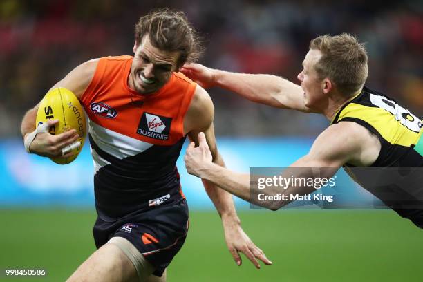 Phil Davis of the Giants is tackled by Jack Riewoldt of the Tigers during the round 17 AFL match between the Greater Western Sydney Giants and the...