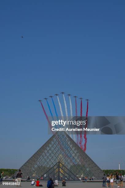 Patrouille de France jets fly over the Louvre pyramide during the Bastille day ceremony on July 14, 2018 in Paris, France. The Bastille Day Military...