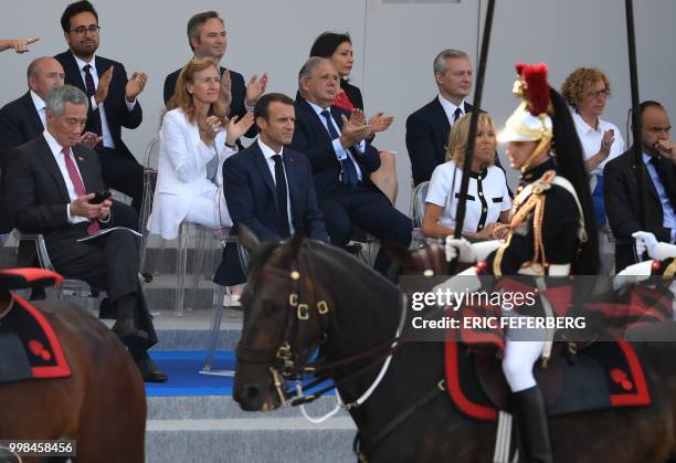French President Emmanuel Macron sits with his wife Brigitte Macron as French Labour Minister Muriel Pénicaud , French Prime Minister Edouard...