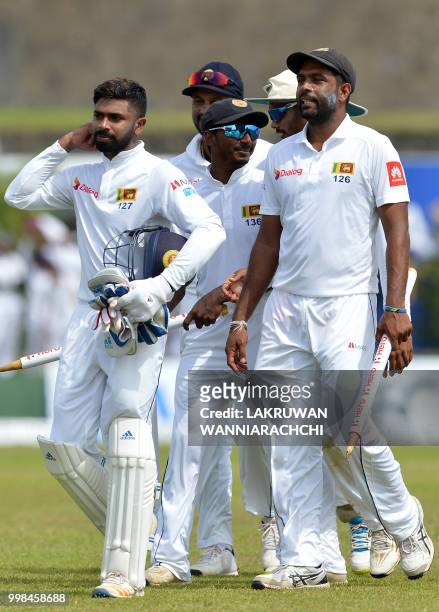Sri Lanka's Dilruwan Perera and teammates leave the grounds with the stumps after victory in the opening Test match between Sri Lanka and South...