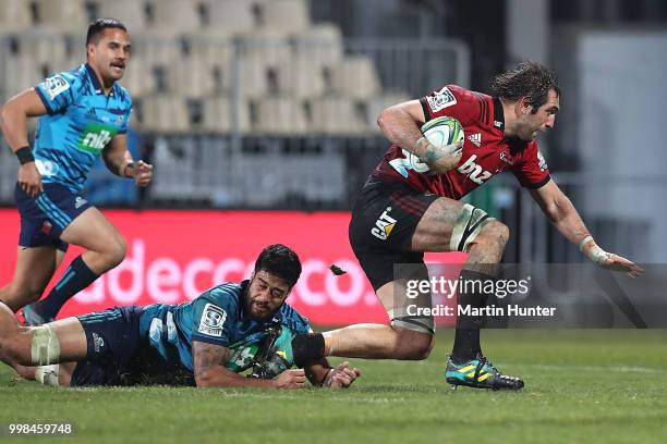 Sam Whitelock of the Crusaders breaks out of the tackle of Akira Ioane of the Blues to score a try during the round 19 Super Rugby match between the...