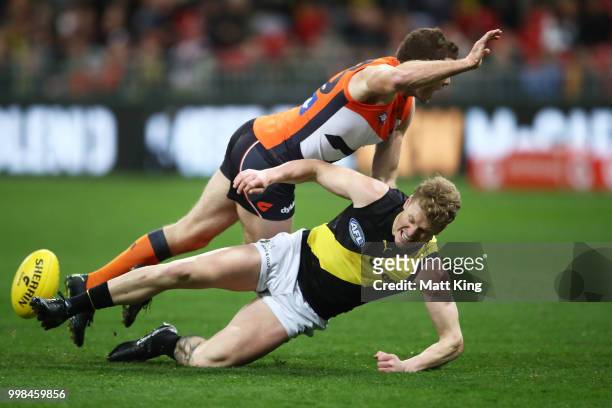 Josh Caddy of the Tigers is challenged by Heath Shaw of the Giants during the round 17 AFL match between the Greater Western Sydney Giants and the...