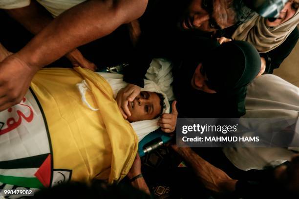 Palestinian mother of 15-year-old Palestinian protester Othman Rami Halles mourns over the death of her son during his funeral east of Gaza City on...
