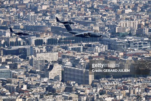 An aerial view shows an Airbus A400M Atlas and two CASA aircrafts flying over the city during the annual Bastille Day military parade on the...