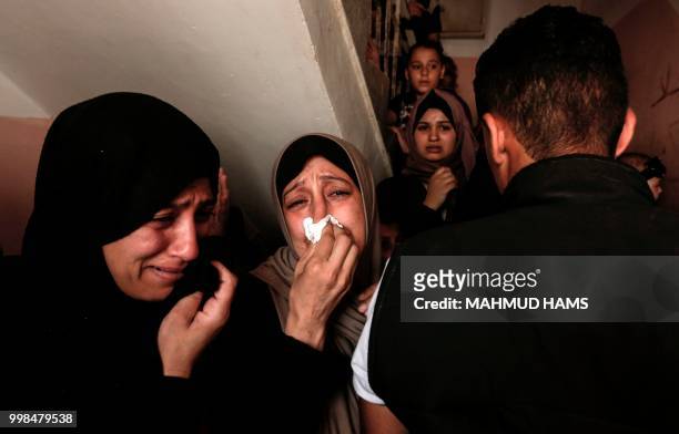 Palestinians and relatives mourn over the death of 15-year-old protester Othman Rami Halles during his funeral east of Gaza City on July 14, 2018. -...