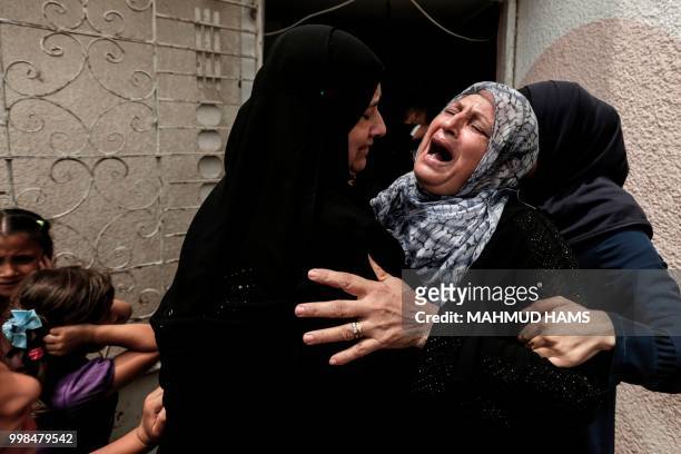 Palestinians and relatives mourn over the death of 15-year-old protester Othman Rami Halles during his funeral east of Gaza City on July 14, 2018. -...