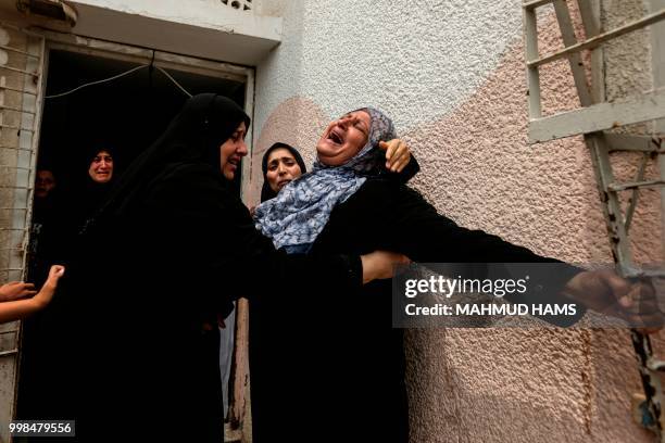 Palestinians and relatives mourn over the death of 15-year-old protester Othman Rami Halles during his funeral east of Gaza City on July 14, 2018. -...