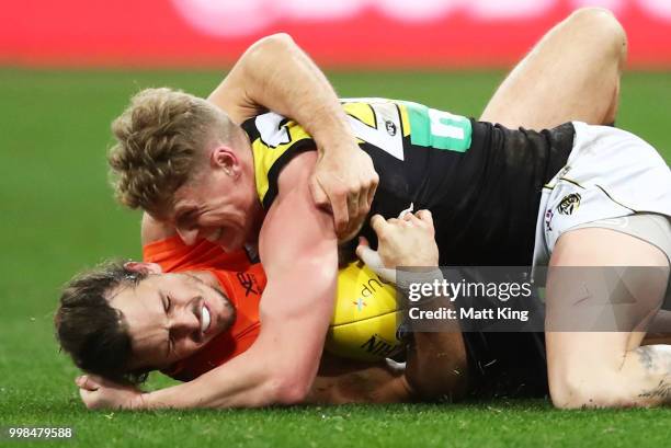 Phil Davis of the Giants competes for the ball against Josh Caddy of the Tigers during the round 17 AFL match between the Greater Western Sydney...