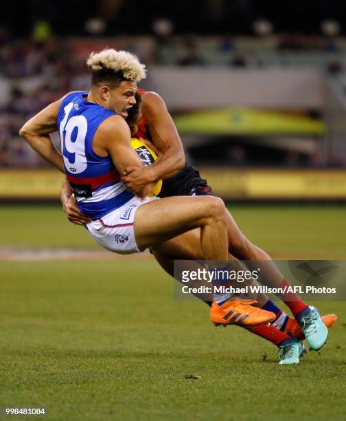 Jay Kennedy Harris of the Demons is tackled by Jason Johannisen of the Bulldogs during the 2018 AFL round 17 match between the Melbourne Demons and...