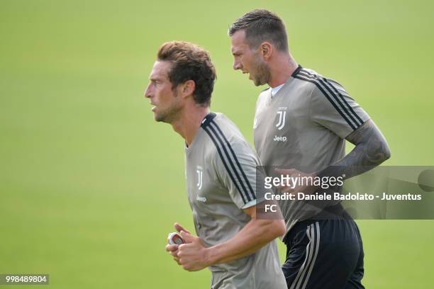 Claudio Marchisio and Federico Bernardeschi during a Juventus morning training session on July 14, 2018 in Turin, Italy.