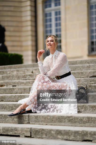 Karlie Kloss wears a white lace dress, outside Dior, during Paris Fashion Week Haute Couture Fall Winter 2018/2019, on July 2, 2018 in Paris, France.