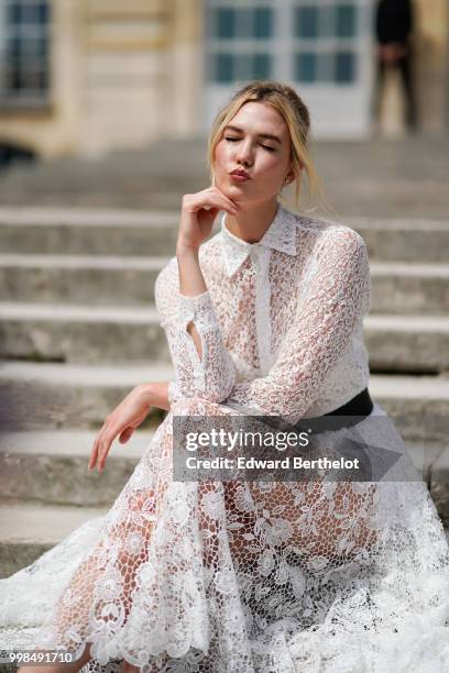 Karlie Kloss wears a white lace dress, outside Dior, during Paris Fashion Week Haute Couture Fall Winter 2018/2019, on July 2, 2018 in Paris, France.