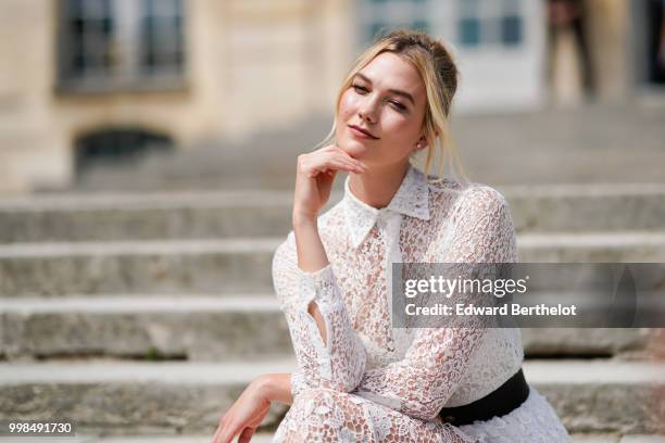 Karlie Kloss wears a white lace dress, outside Dior, during Paris Fashion Week Haute Couture Fall Winter 2018/2019, on July 2, 2018 in Paris, France.