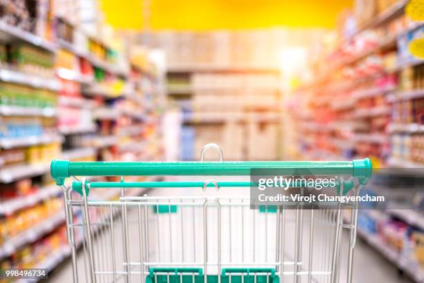 empty shopping cart in the supermarket shopping mall - travée photos et images de collection
