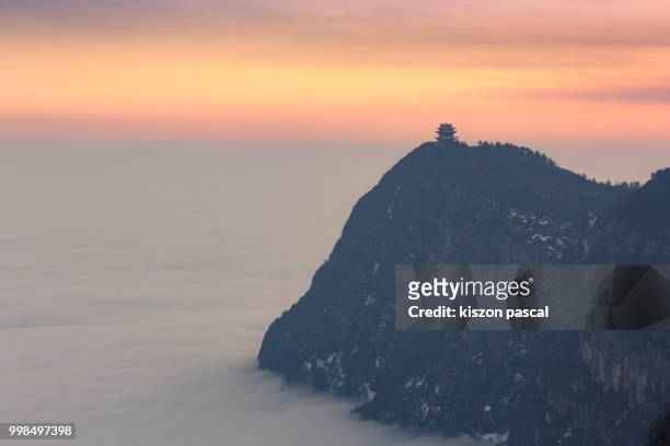 temple at the top of the emeishan mountain with seacloud during sunset , sichuan province , china - emei shan stockfoto's en -beelden