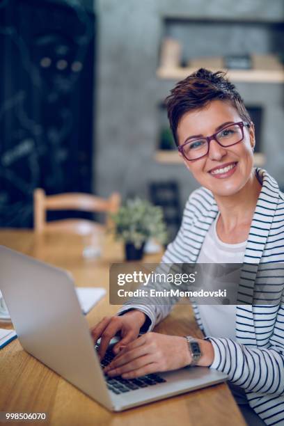 young businesswoman using laptop in the office - emir memedovski stock pictures, royalty-free photos & images