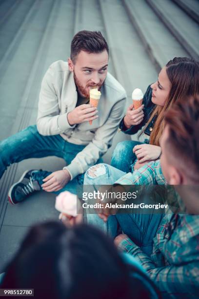 dos jóvenes parejas comiendo helado en pasos en el centro de la ciudad - aleksandar georgiev fotografías e imágenes de stock