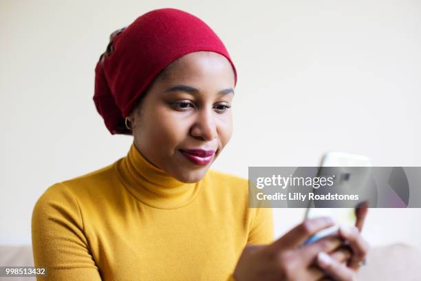 young muslim woman using mobile phone - lilly roadstones stock pictures, royalty-free photos & images