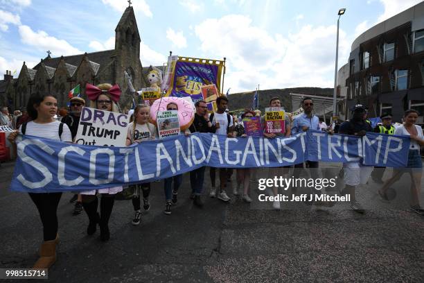 People hold a large anti-Trump banner and other signs while the U.S. President is visiting Trump Turnberry Luxury Collection Resort in Scotland as...