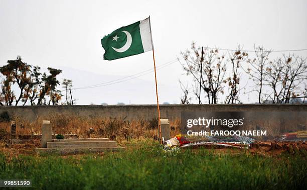 Pakistan-unrest-military,FEATURE by Khurram Shahzad In this picture dated February 21 a Pakistani national flag stands next to the grave of a...