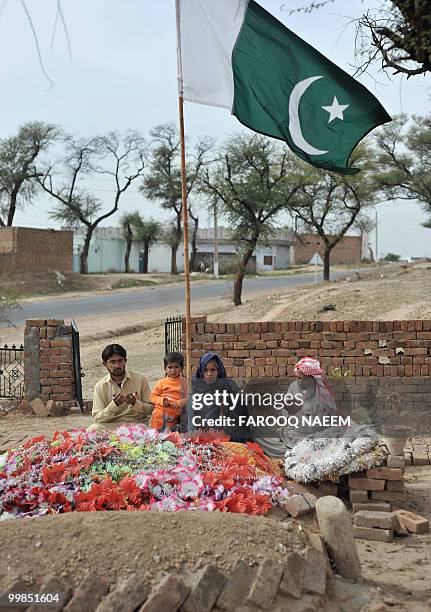 Pakistan-unrest-military,FEATURE by Khurram Shahzad In this picture dated February 21 a Pakistani national flag flutters above relatives as they pray...