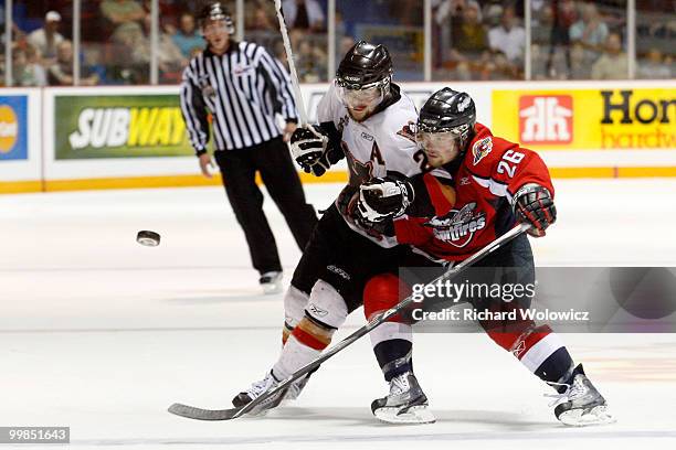 Del Cowan of the Calgary Hitmen and Kenny Ryan of the Windsor Spitfires chase the puck during the 2010 Mastercard Memorial Cup Tournament at the...