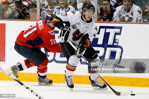 Giffen Nyren of the Calgary Hitmen stick handles the puck while being chased by Dale Mitchell of the Windsor Spitfires during the 2010 Mastercard...
