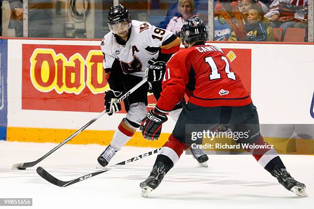 Ian Schultz of the Calgary Hitmen shoots the puck in front of Marc Cantin of the Windsor Spitfires during the 2010 Mastercard Memorial Cup Tournament...