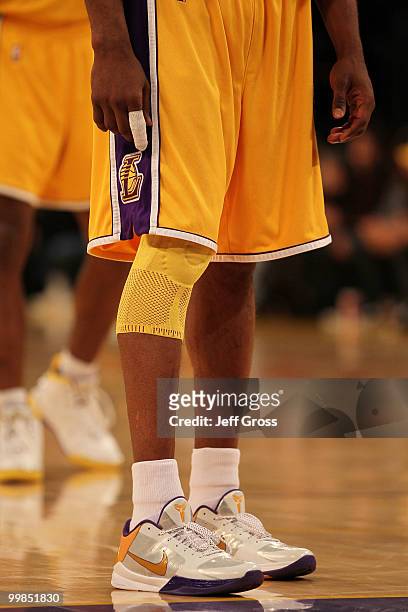 Guard Kobe Bryant of the Los Angeles Lakers stands with his finger wrapped and knee in a brace during the game against the Phoenix Suns in Game One...