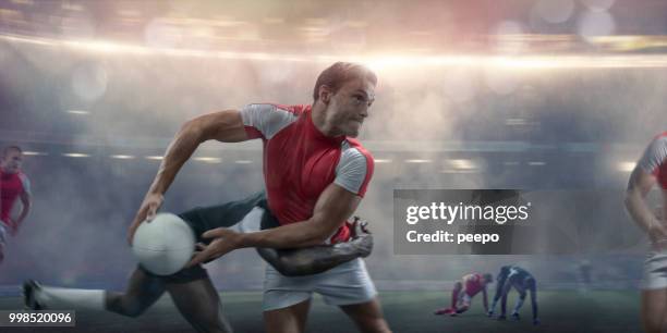 rugby player about to pass whilst being tackled during match - rugby stadium stock pictures, royalty-free photos & images