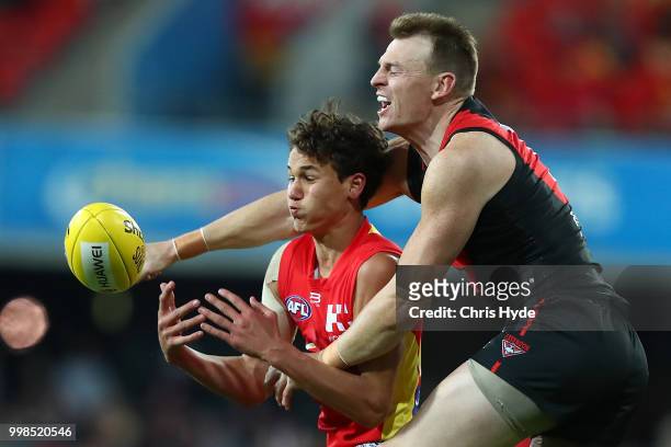 Wil Powell of the Suns and Brendon Goddard of the Bombers compete for the ball during the round 17 AFL match between the Gold Coast Suns and the...