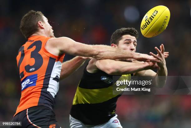 Jason Castagna of the Tigers is challenged by Heath Shaw of the Giants during the round 17 AFL match between the Greater Western Sydney Giants and...