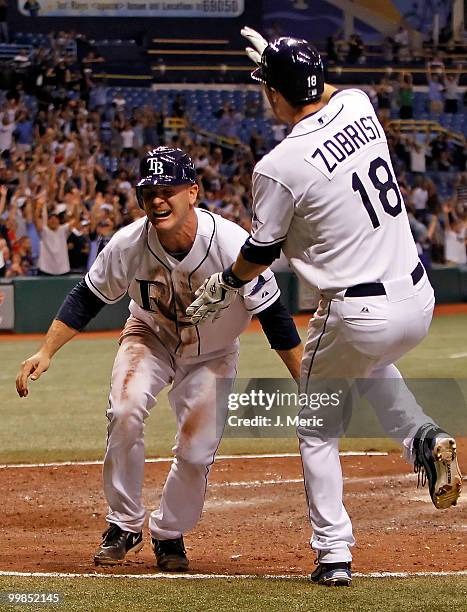 Catcher John Jaso is congratulated by Ben Zobrist of the Tampa Bay Rays after scoring the winning run in the bottom of the eleventh against the...