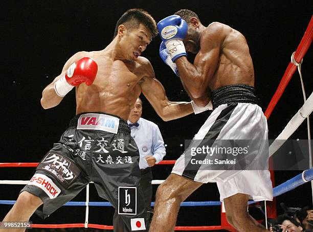 Champion Takashi Uchiyama of Japan hits his left on challenger Angel Granados of Venezuela during the WBA Super Featherweight Title Fight at Saitama...