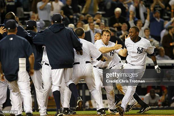 Marcus Thames of the New York Yankees is congratulated by his teammates following his two-run walk off in the ninth inning to beat the Boston Red Sox...