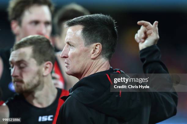 Bombers coach John Worsfold talks to players during the round 17 AFL match between the Gold Coast Suns and the Essendon Bombers at Metricon Stadium...