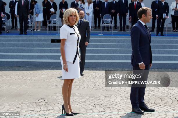 Wife of French President Brigitte Macron, French Prime Minister Edouard Philippe and French President Emmanuel Macron leave after the annual Bastille...