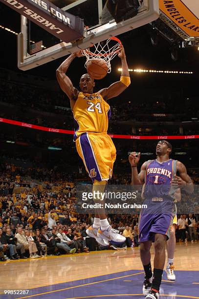 Kobe Bryant of the Los Angeles Lakers dunks against Amar'e Stoudemire of the Phoenix Suns in Game One of the Western Conference Finals during the...