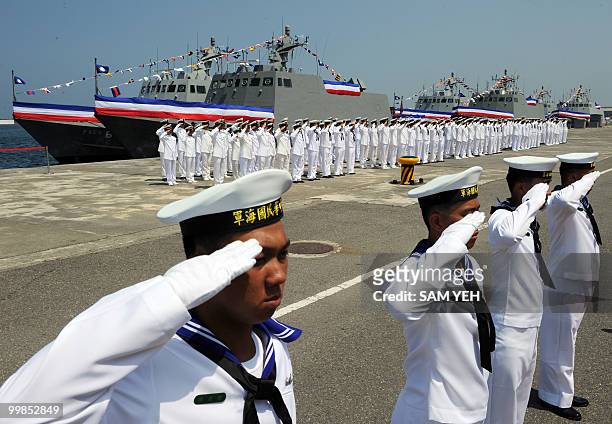 Navy soldiers salute in front of a homemade missile boats during the inauguration ceremony at the Tsuoying naval base in southern Taiwan on May 18,...