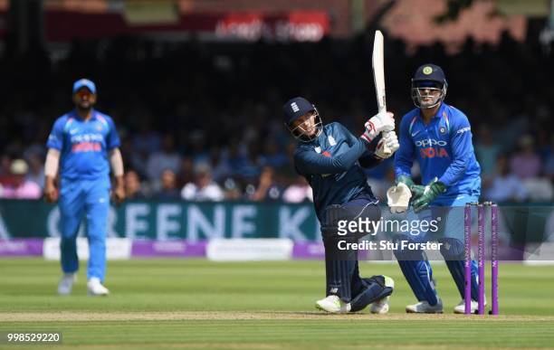 England batsman Joe Root hits out watched by MS Dhoni during the 2nd ODI Royal London One Day International match between England and India at Lord's...