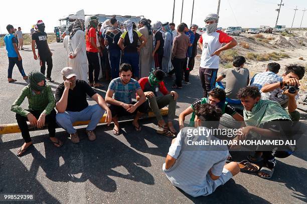 Protesters block the road as they demonstrate against unemployment in front of oil fields in al-Qurnah, some 100 kilometers north of Basra, southern...
